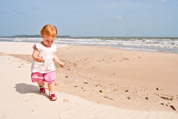 Meisje 1,5 jaar oud met schelpen in de handen wandelingen langs de kust van de Golf van thailand — Stockfoto