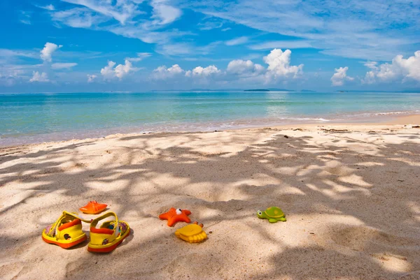 Children's footwear and toys on the sand, Gulf of Thailand — Stock Photo, Image