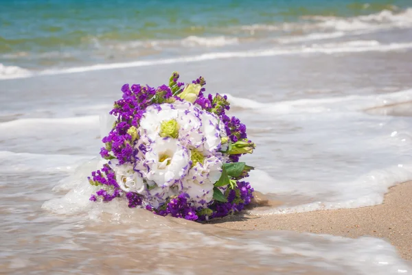 Buquê da noiva em uma onda do mar — Fotografia de Stock