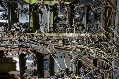Kesik kablolar ve paslı parçalarla eski elektrik paneli