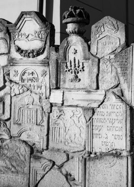 Chernivtsi city, Ukraine, 2022.04.11, Memorial wall with broken tombstones at the Jewish cemetery.