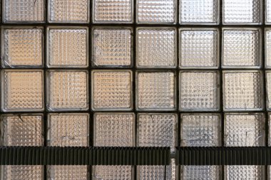 Dikdörtgen bloklardan yapılmış, aşınma izleri olan desenli cam duvar.