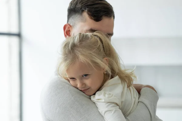 Portret van een schattig klein meisje in haar vaders armen. Een vader en zijn dochter, een klein meisje, knuffelen. — Stockfoto