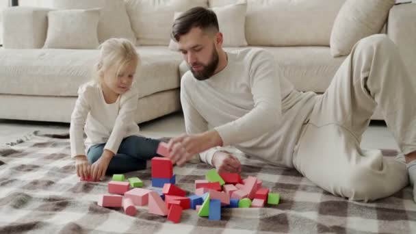 Sakallı baba ve kızı evde birlikte zar oynuyorlar, oturma odasında yerde oturuyorlar.. — Stok video