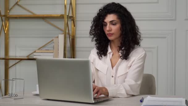 Moe van de jonge Indiase krullende vrouw, lijden aan migraine, overladen met werk op een laptop. Een uitgeputte vrouw voelt zich slecht, raakt haar slapen aan met haar handen — Stockvideo