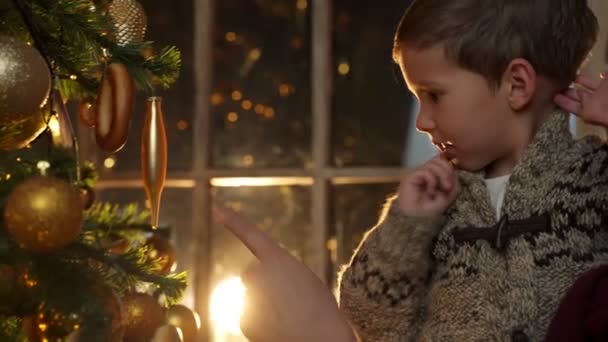Een vader en zijn zoontje versieren een kerstboom. Kerst versierd interieur. Het concept van een gezinsvakantie. — Stockvideo