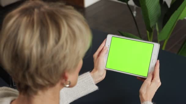 Žena středního věku si prohlíží obsah tabletu na zelené obrazovce — Stock video