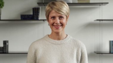 Ofisteki neşeli olgun kadın kameraya bakıyor. Başarılı bir kadın gülümser ve kendine güvenir..