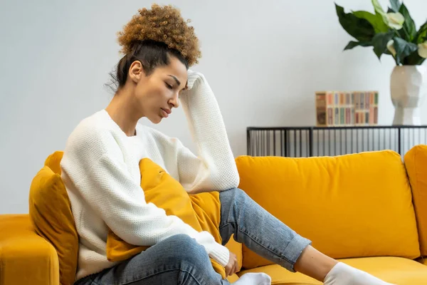 Trieste jonge zwarte vrouw zit alleen thuis, zich depressief, boos, een vrouw die lijdt aan verdriet of schuld, bezorgd over problemen — Stockfoto