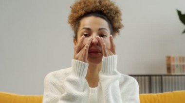 Genç bir kadın sağlıklı tenine dokunuyor. Afro-Amerikan kadın gülümsüyor. Gençlik ve cilt bakımı kavramı