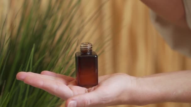 Droppar av olja serum tinktur från en pipett i en flaska — Stockvideo