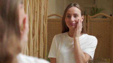 aynabakarken yüze dokunan güzel gülümseyen genç kadın