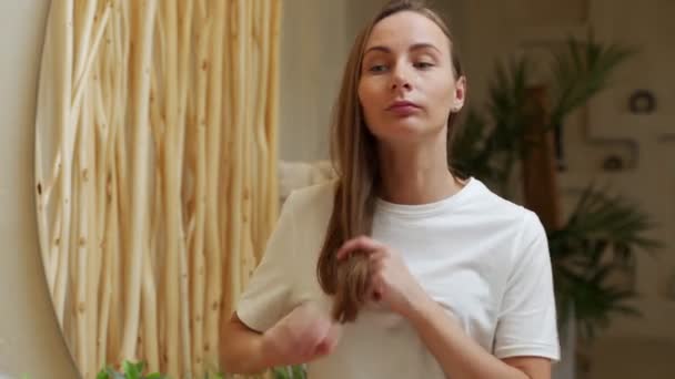 Nő tartja a hosszú haj, nézi a sérült törött végek, problémák a hajápolás — Stock videók