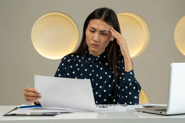 Asian woman covers her face with her hand and gets upset from working in front of a laptop on a desk in the office — 图库照片