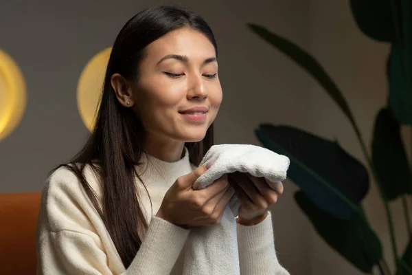 Asian woman enjoys a clean and smelling towel after washing with a new washing gel — Stockfoto