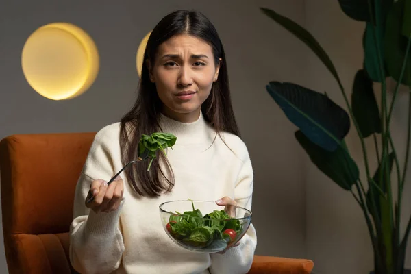 Mujer asiática infeliz en una dieta, no le gusta comer alimentos y verduras saludables — Foto de Stock
