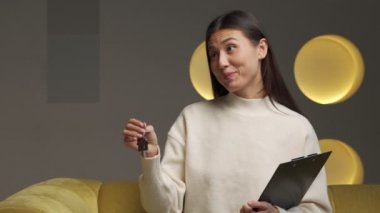 The real estate agent hands over the keys to the house to a young woman