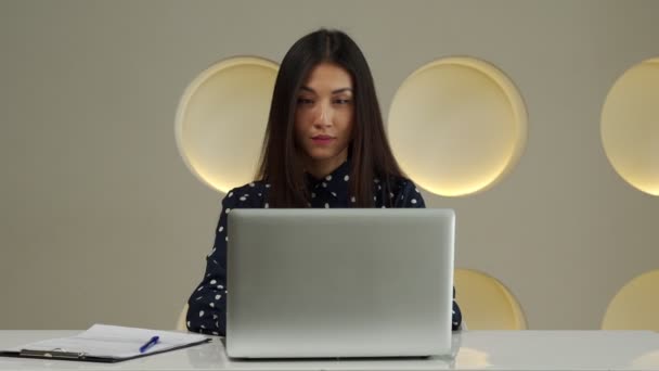 Young asian woman working at the office using a laptop Looking at the camera. — Vídeo de Stock