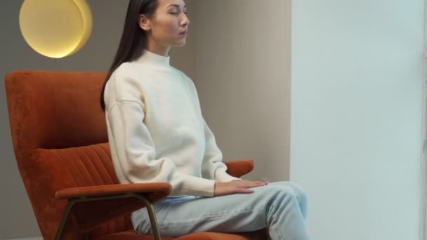 Smiling Asian woman resting in a comfortable chair, happy after the work done, enjoying the rest with her eyes closed — Stock video