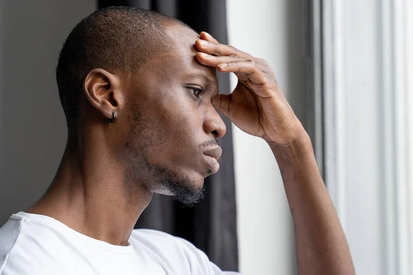 El hombre negro que sufre de un terrible dolor de cabeza severo toca su frente. Los problemas con las enfermedades cerebrales causan dolor de cabeza severo crónico —  Fotos de Stock