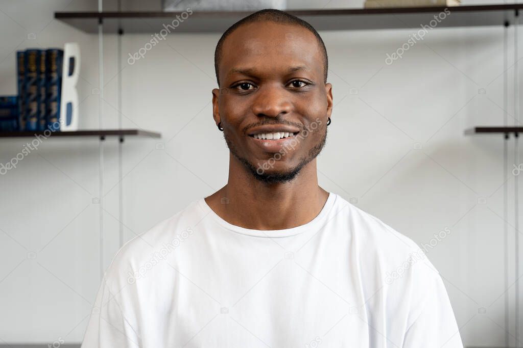 Confident smiling young black businessman looks at the camera in the office