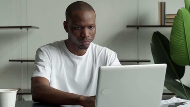 Gelukkig opgewonden zakenman viert zijn succes. De winnaar, een zwarte man op kantoor die het nieuws leest op een laptop. — Stockvideo