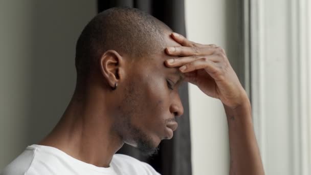 A fekete férfi, akinek szörnyű fejfájása van, megérinti a homlokát. Az agyi megbetegedések krónikus, súlyos fejfájást okoznak — Stock videók