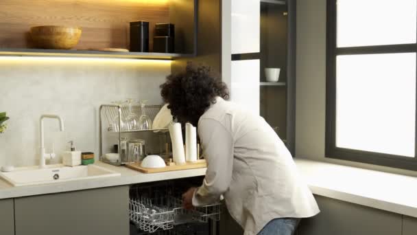 Muzułmanin bierze czyste okulary ze zmywarki do naczyń w kuchni — Wideo stockowe