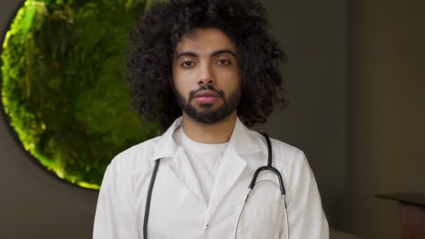 Egyptian doctor with stethoscope on neck looks in camera — Stock Video