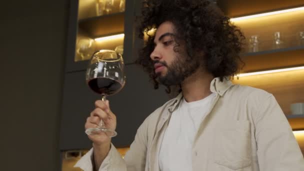 Egyptský muž drží sklenici červeného vína vonící před pitím — Stock video