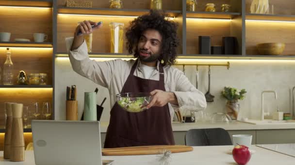 Koch eines muslimischen Mannes zeichnet Prozess beim Kochen von Gericht in Küche auf — Stockvideo