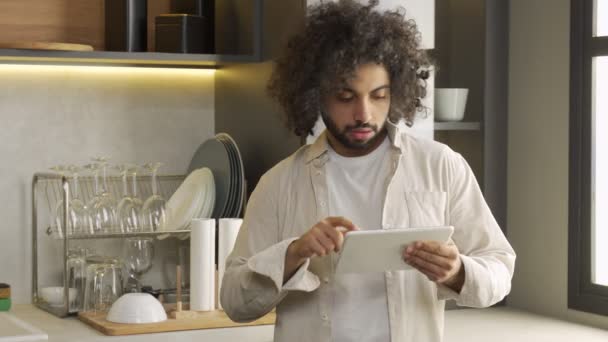 Junger Ägypter bestellt Essen per Tablet in der heimischen Küche — Stockvideo