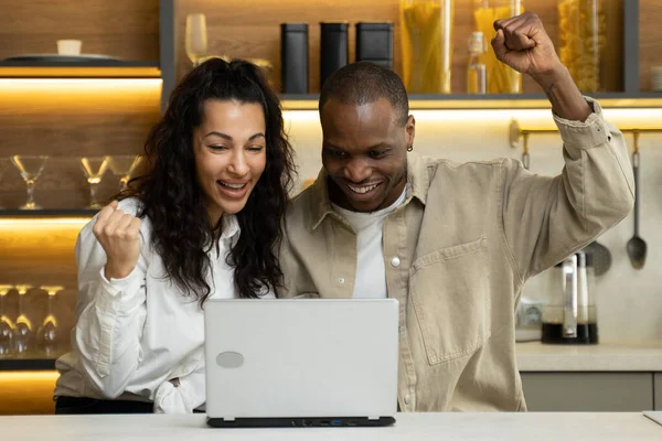 Alegre pareja consigue feliz ganar la lotería en el ordenador portátil en casa — Foto de Stock