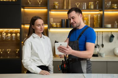 Foreman tablette kadın mutfak yenileme planını gösteriyor.