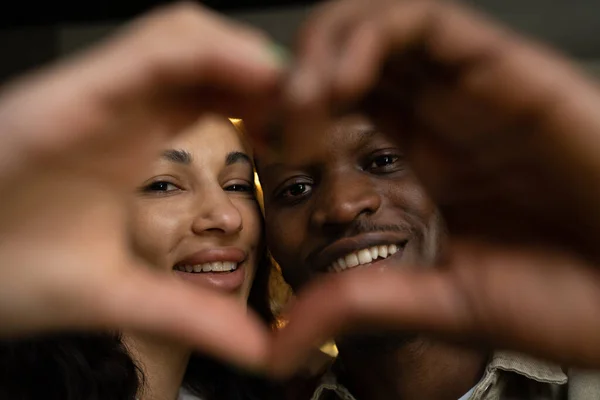 Gelukkig paar in liefde maakt vorm van hart met vingers — Stockfoto