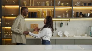 Mutlu çok ırklı çift modern mutfakta birlikte dans ediyor.