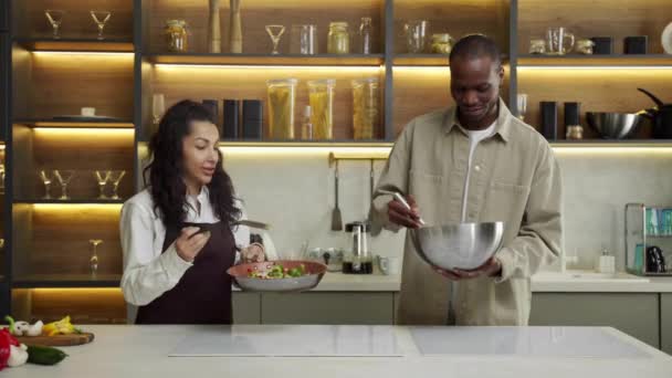 Mladý pár kuchaři vařit lahodné jídlo na večeři v kuchyni — Stock video
