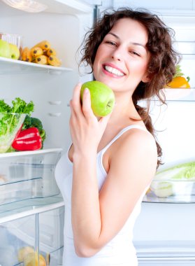sağlıklı gıda ile buzdolabı yakınındaki güzel genç kadın