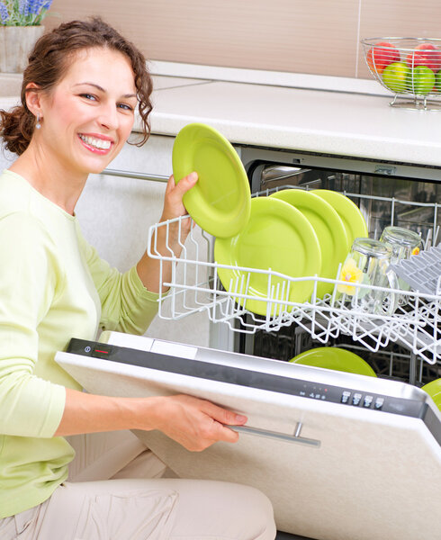 Dishwasher. Young woman in the Kitchen doing Housework. Wash-up