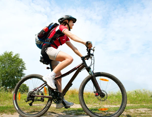 外で自転車に乗る幸せな若い女性。健康的なライフスタイル — ストック写真