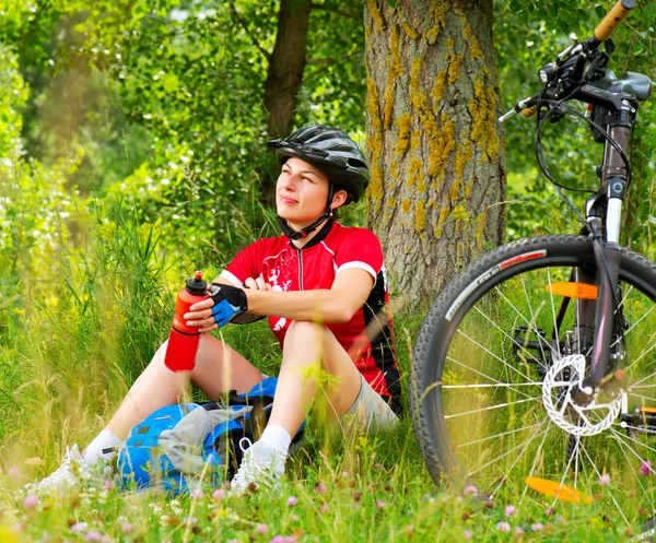 外で自転車に乗る幸せな若い女性。健康的なライフスタイル — ストック写真