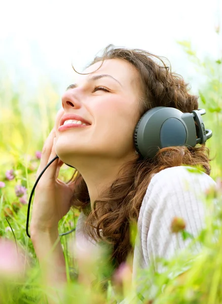 Schöne junge Frau mit Kopfhörern im Freien. Musik genießen — Stockfoto