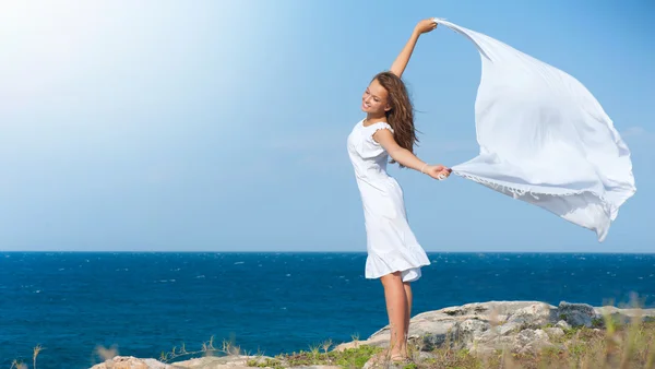 Vrijheid concept. meisje met witte sjaal staande op de rots — Stockfoto