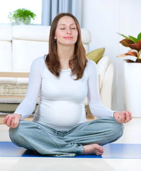 Schöne schwangere Frau beim Yoga zu Hause — Stockfoto