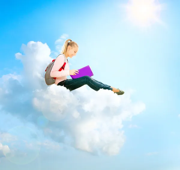 School meisje of student zittend op een wolk en lezen van een boek — Stockfoto