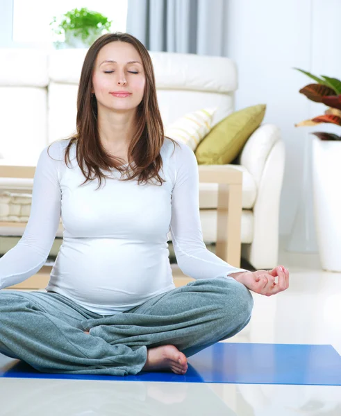 Vackra gravid kvinna gör yoga hemma — Stockfoto