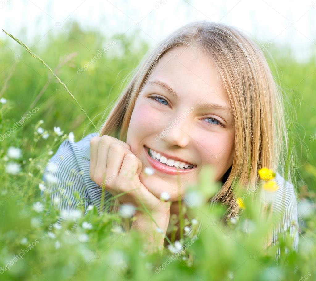 Smiling Girl Relaxing outdoors. Meadow