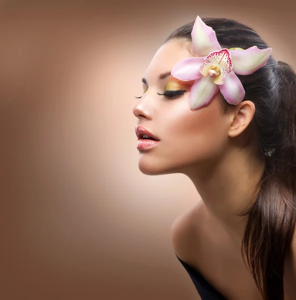 Retrato de Beleza. Menina elegante bonita com flor de orquídea — Fotografia de Stock