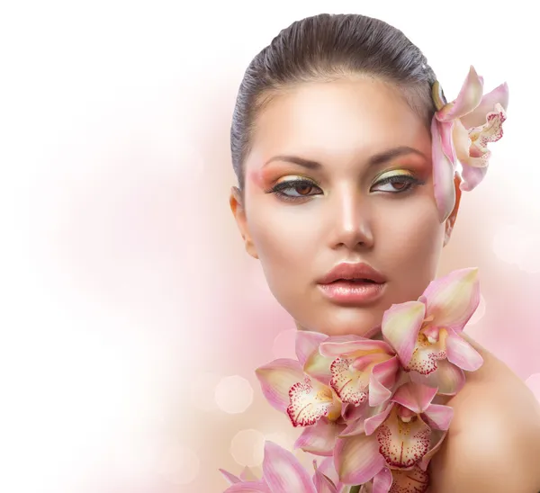 Hermosa chica con flores de orquídea. Maquillaje perfecto — Foto de Stock