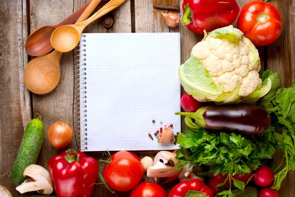 Öppna anteckningsboken och färska grönsaker bakgrund. kost — Stockfoto